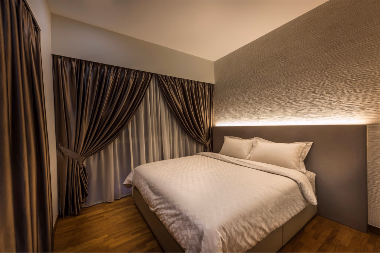 Bronze double-pleat night curtains with sheer day curtains behind, tied back in a Singapore bedroom